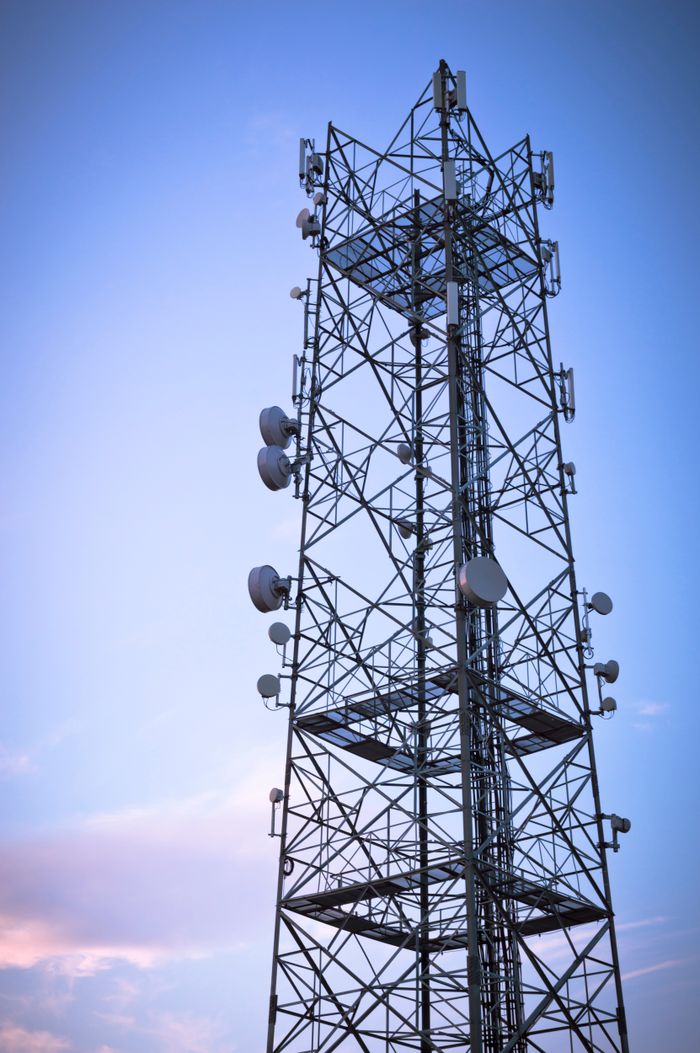 Crafting Captivating Headlines: Your awesome post title goes here A telecommunications tower with satellite dishes silhouetted against a blue sky, showcasing modern communication technology.